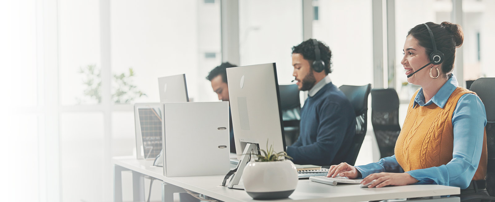 A support and operations team wearing headsets at their desks